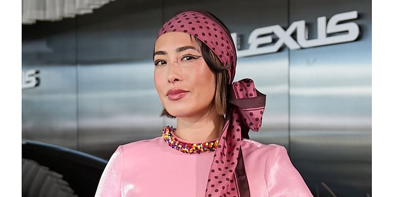 Melissa Leong puts on a very quirky display in a bright pink satin dress with beaded rainbow cuffs as she attends Crown Oaks Day in Melbourne