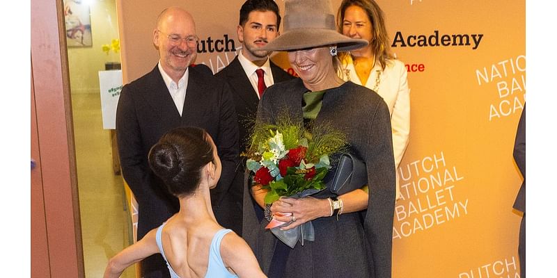 Queen Maxima braves the rain in a fabulous wide-brimmed hat to visit the National Ballet Academy