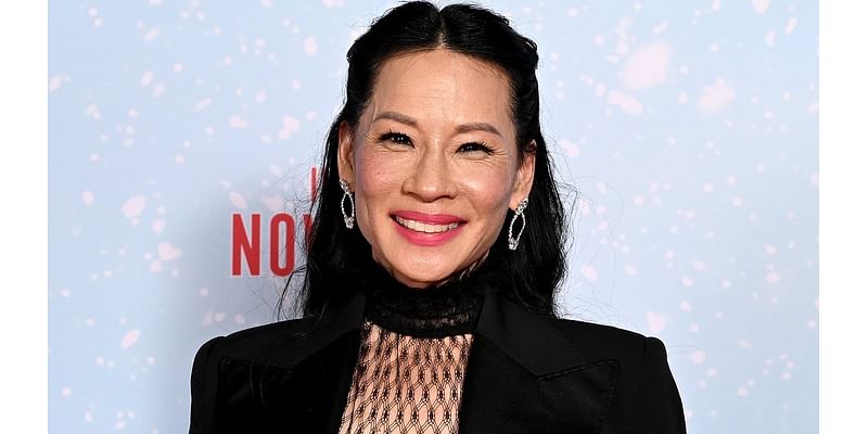 Lucy Liu flashes her legs in sheer tights as she joins Dwayne 'The Rock' Johnson at Red One screening