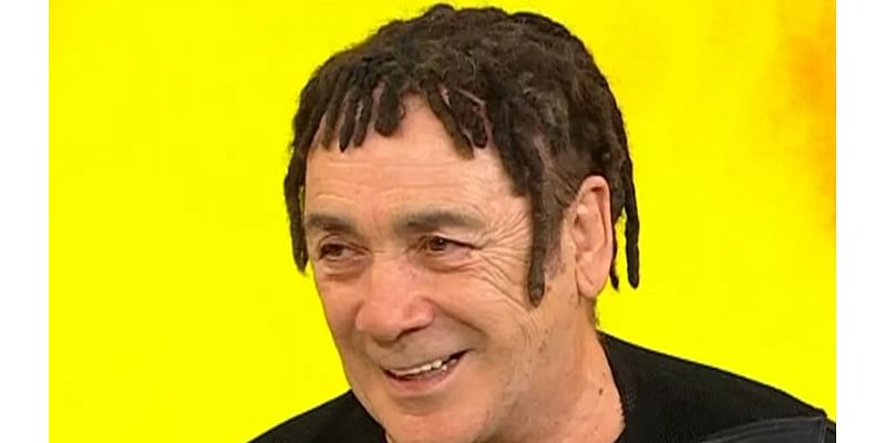 Guess who? Iconic seventies rocker looks unrecognisable as he debuts bizarre dreadlock hairstyle during rare TV appearance