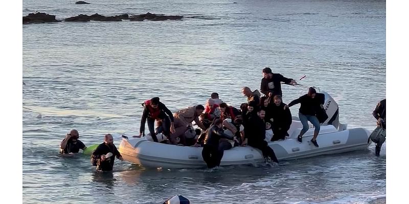 Moment dinghy of migrants land on idyllic Greek beach as shocked British tourists look on