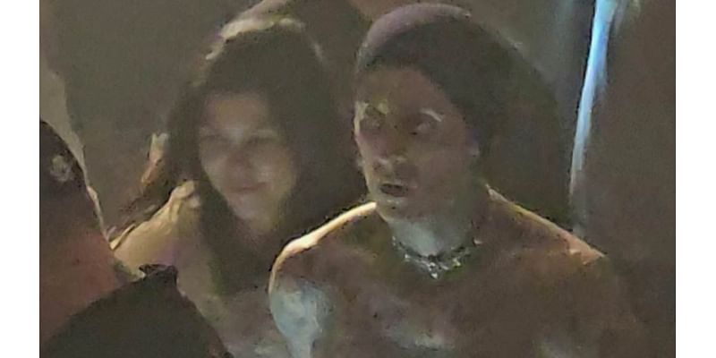 Kourtney Kardashian and her shirtless husband Travis Barker hold hands as they leave his Blink-182 concert in Las Vegas