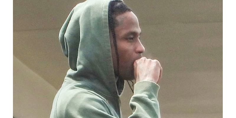 Travis Scott puffs on a suspicious-looking cigarette as he admires the view from his luxury hotel balcony on Sydney's harbourside