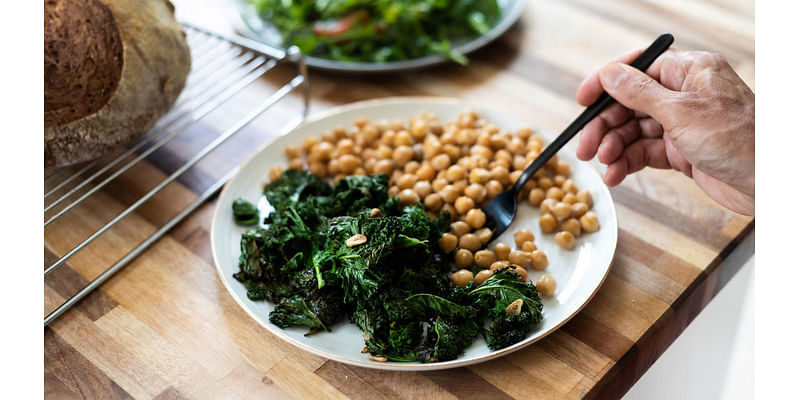 Why do leafy green vegetables interact with blood thinners?