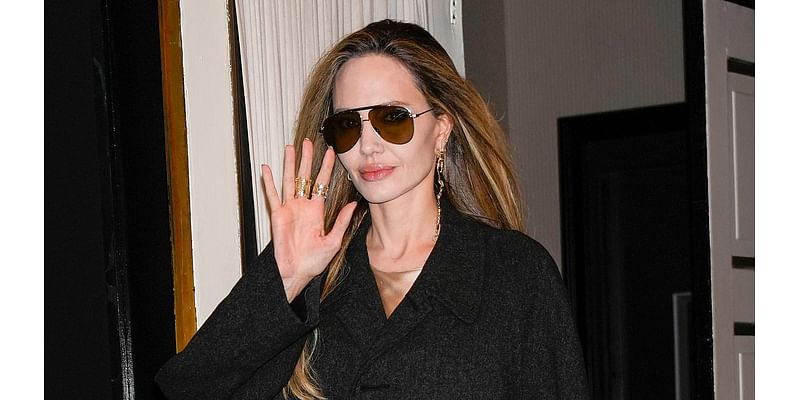 Angelina Jolie cuts a typically chic figure in a sleek black coat and shades as she steps out in New York following a Q&A about new film Maria