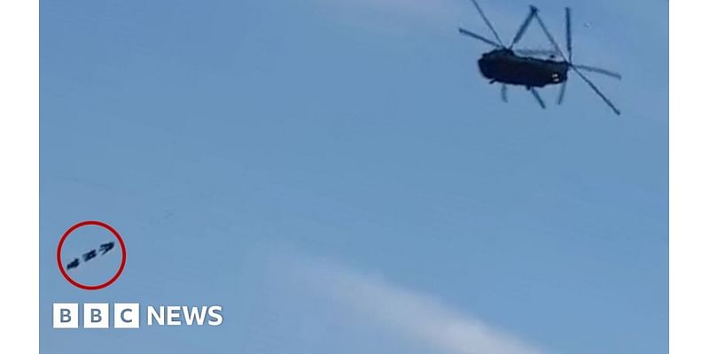 Special forces dangle from Chinook helicopter over town