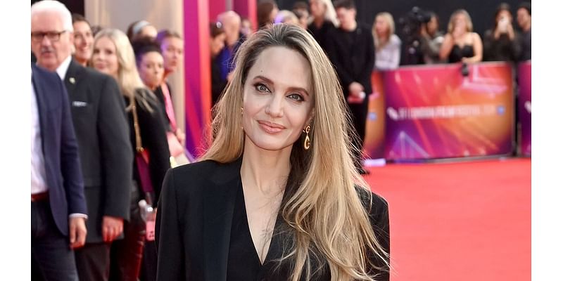 Angelina Jolie cuts a glamorous figure in black suit and boots as she attends the London premiere of her film Maria