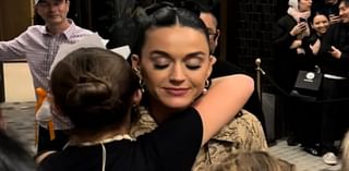 Katy Perry sweetly hugs a young fan as she signs autographs outside her Melbourne hotel after her AFL Grand Final headlining gig