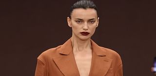 Irina Shayk goes braless beneath a longline tan coat while Amelia Gray Hamlin flashes her abs on the Ferrari runway during Milan Fashion Week