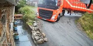 White out! Moment lorry trying to navigate sharp bend on coastal road overturns emptying animal feed all over holiday cottage