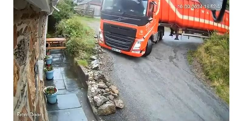 White out! Moment lorry trying to navigate sharp bend on coastal road overturns emptying animal feed all over holiday cottage