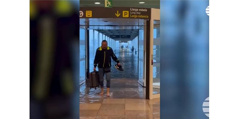 Passengers wade through flood waters inside airport