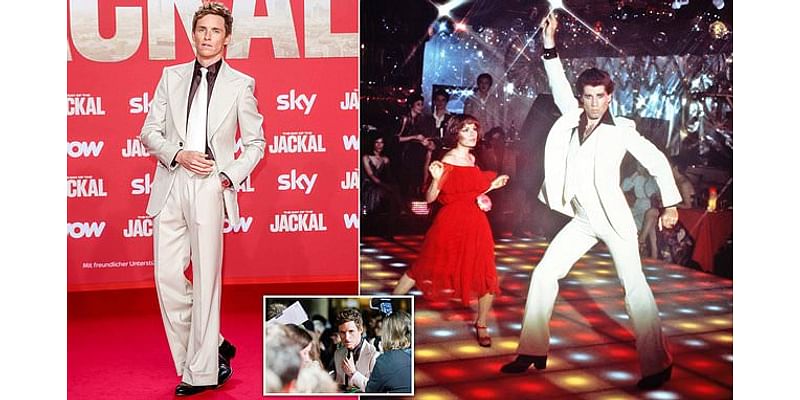 Eddie Redmayne resembles John Travolta in Saturday Night Fever as actors pulls on a white flared suit for the Berlin premiere of The Day Of The Jackal