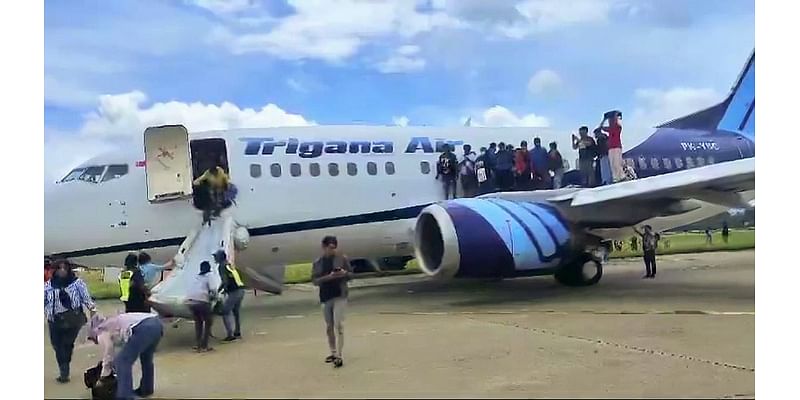 Moment flames shoot from the engine of a Boeing jet before take-off forcing terrified passengers to jump from emergency exits