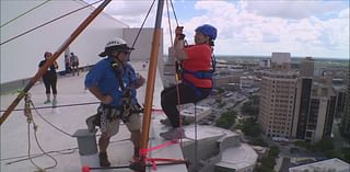 Dozens of people rappel down 20-story San Antonio hotel in effort to raise money for local literacy programs